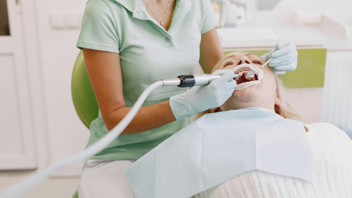 A patient receiving comfortable professional cleaning from a hygienist in a modern clinic